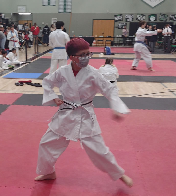 A student is performing a Judo move at a Judo competition.
